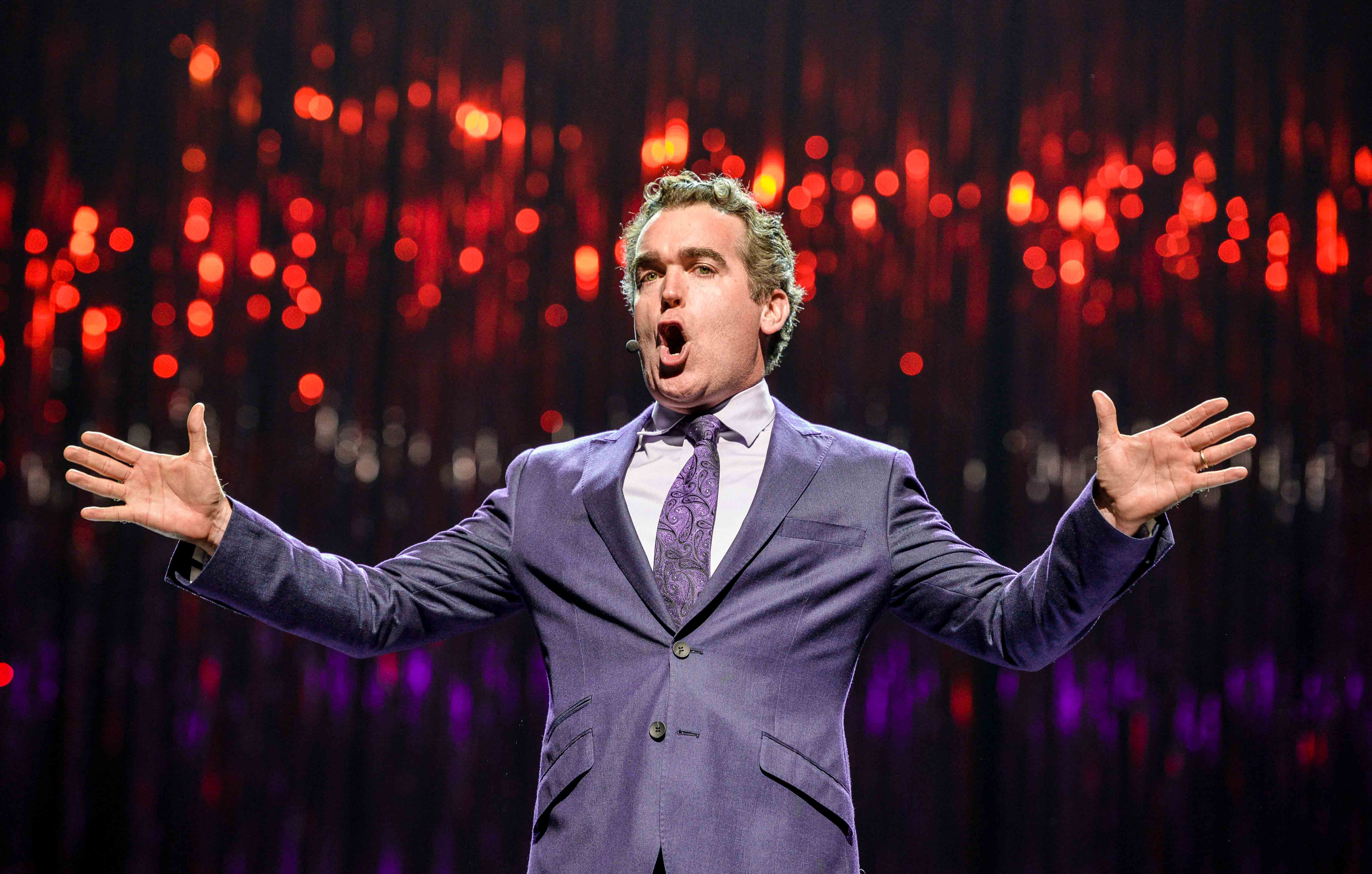 Brian D'Arcy James singing with arms outstretched