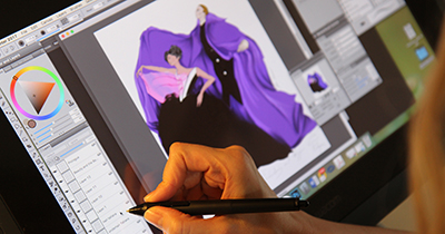 Student hand draws a caped purple costume on computer with digital pen 