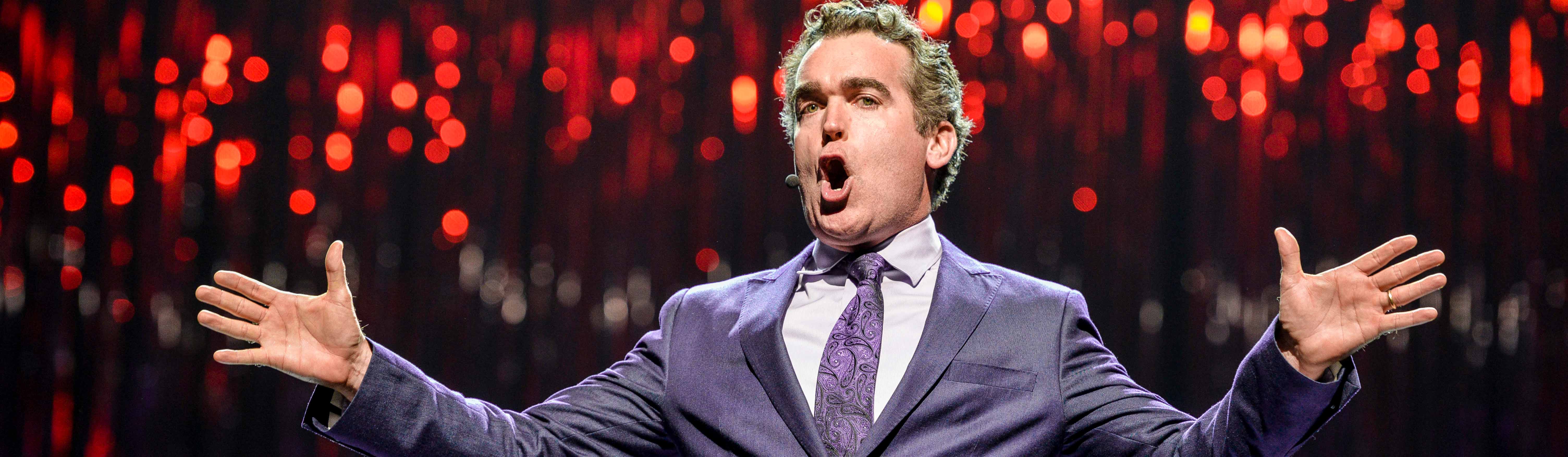 Actor Brian D'Arcy James sings with arms outstretched