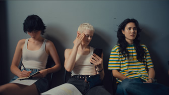 Three people sitting next to each other.