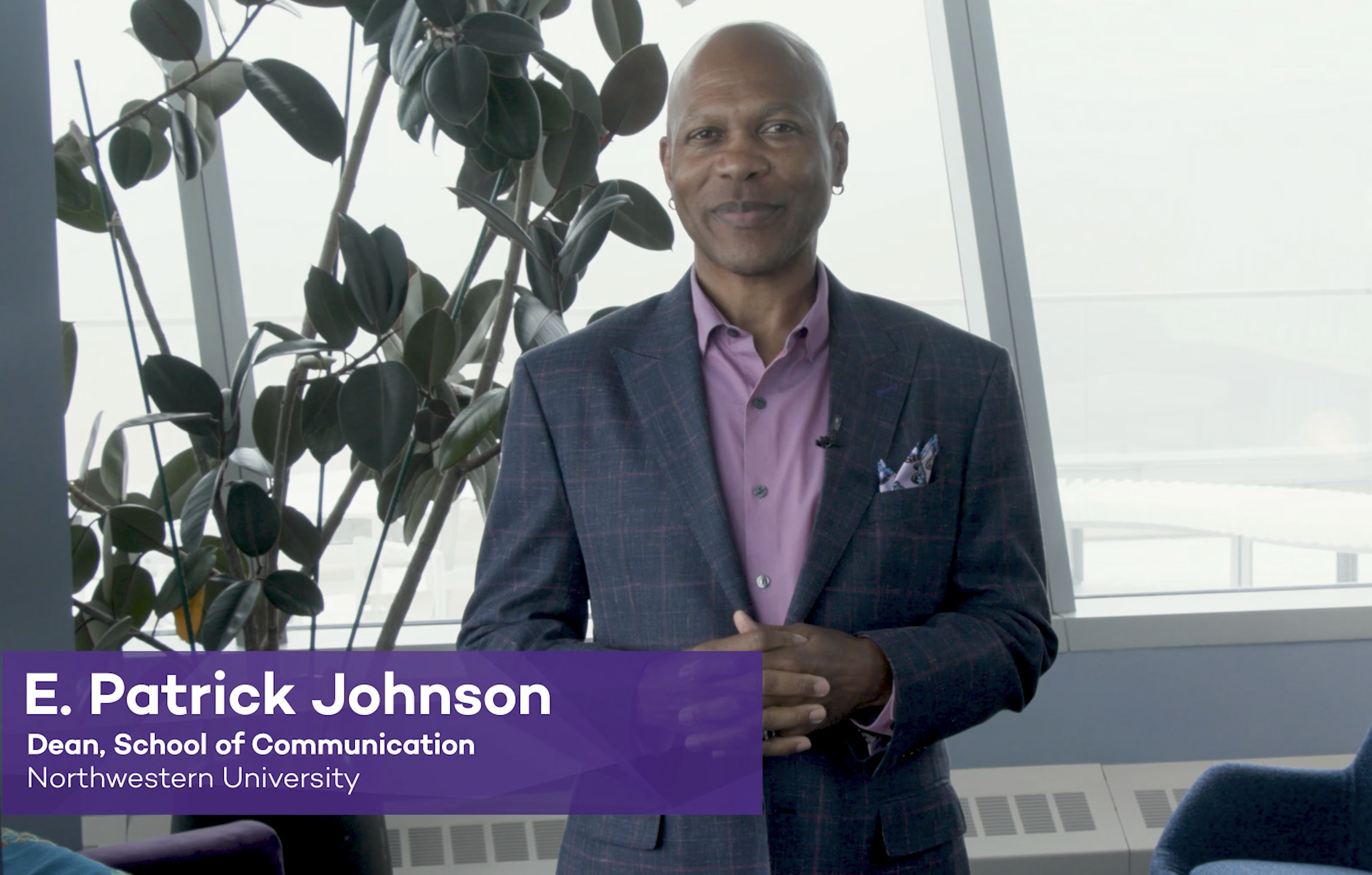 Dean E. Patrick Johnson standing in his office and smiling