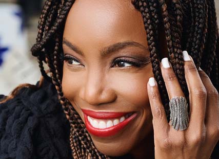 Heather Headley smiles with head in hand